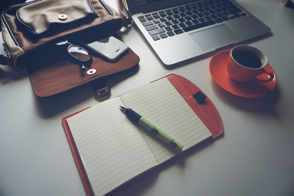 rolled-up university degree resting on a closed laptop next to a smartphone showing freelance app – illustrating skills vs degrees