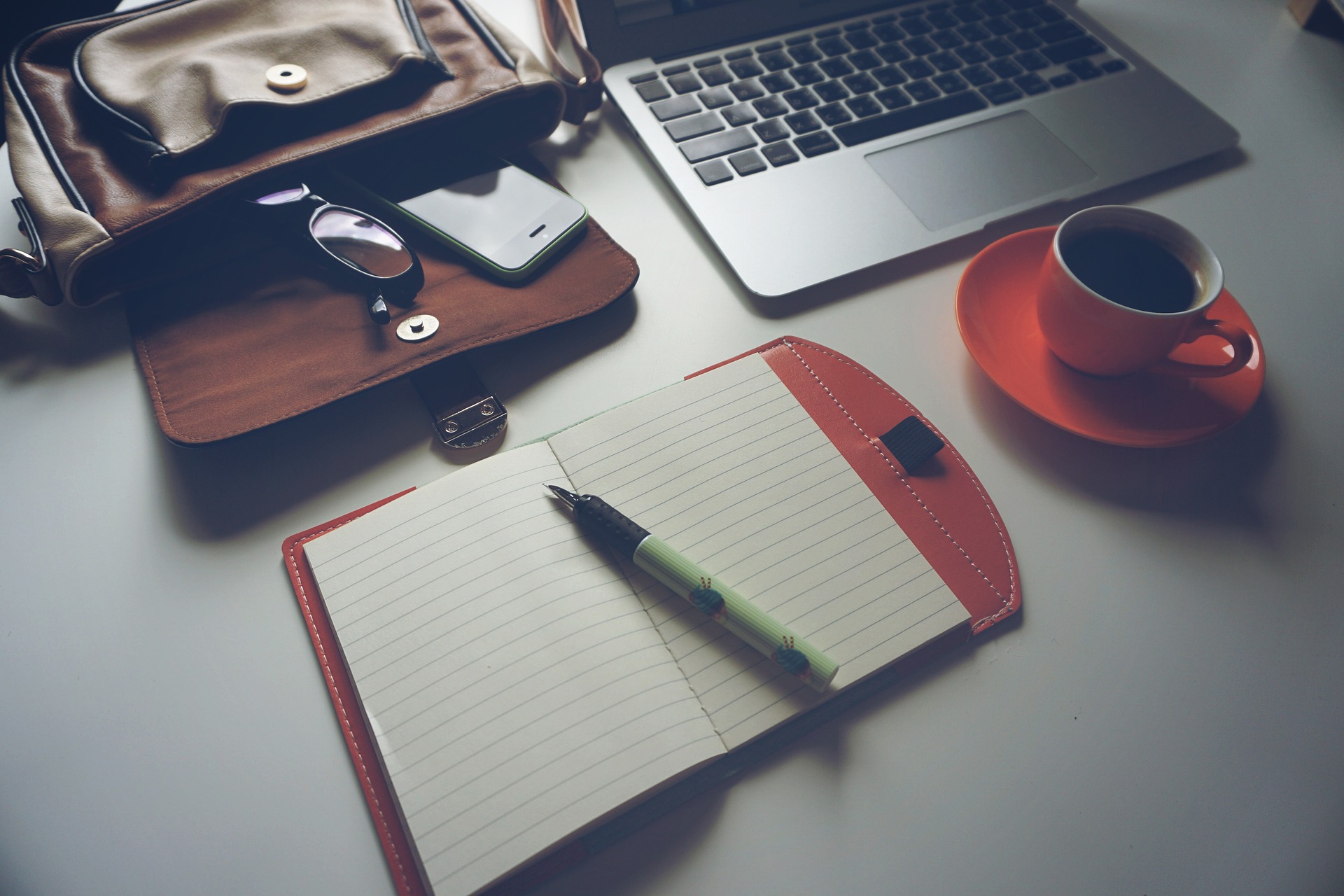 rolled-up university degree resting on a closed laptop next to a smartphone showing freelance app – illustrating skills vs degrees
