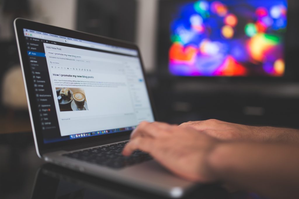 hands typing on a laptop, sticky note reading ‘first client’ on screen – illustrating unemployed to skilled